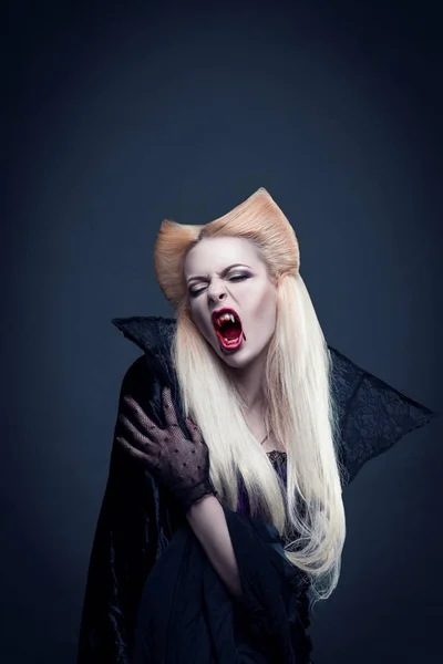 Vacker blond flicka vampyr med blod är på mun och ögon som bär svarta kläder — Stockfoto