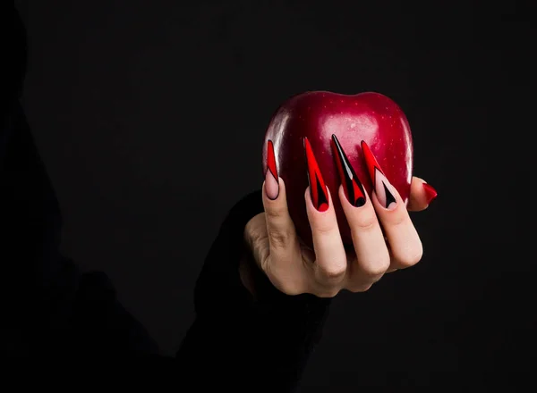 Manos con uñas de miedo manicura sosteniendo manzana roja — Foto de Stock