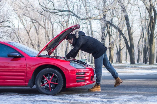 У чоловіка проблеми з машиною на зимовій дорозі . — стокове фото