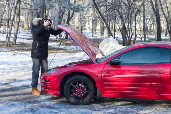 Людина в біді зі своїм зламаним спортивним автомобілем — стокове фото