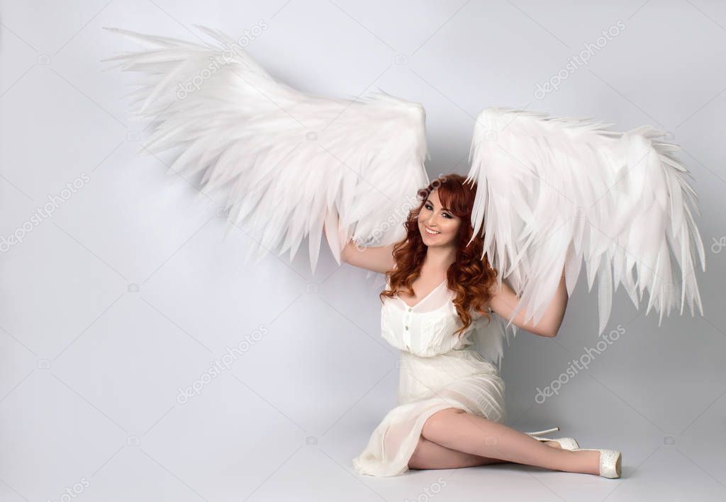 model with open angel wings sitting in studio