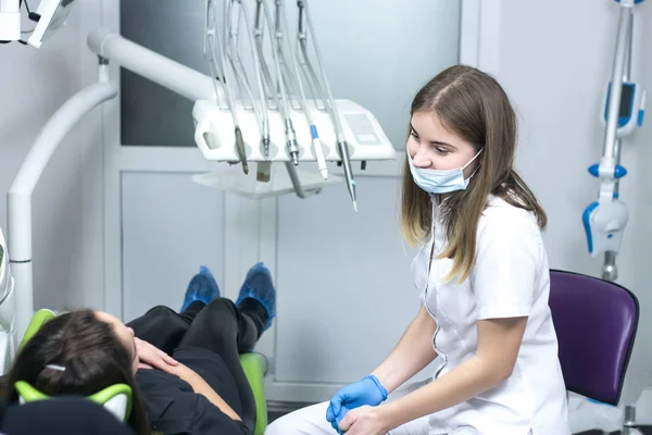 Молодая женщина-дантист улыбается пациентке — стоковое фото