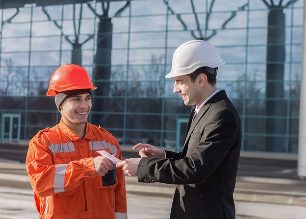 Jefe dando salario en un sobre y sonriendo. efectivo en mano — Foto de Stock