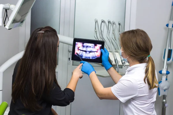 Dentista médico está mostrando dientes de rayos X en el comprimido —  Fotos de Stock