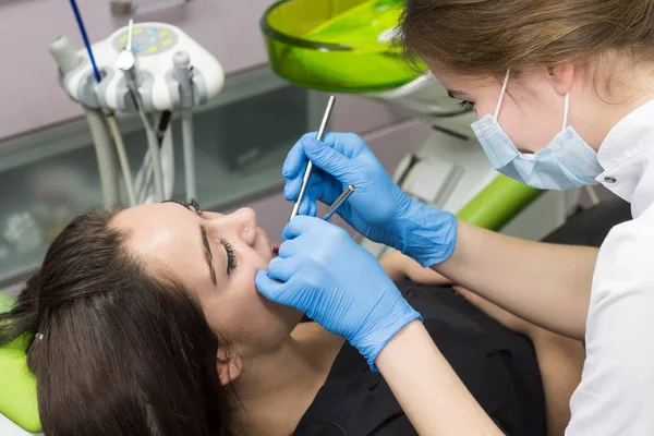 Dentist at work examining woman\'s teeth