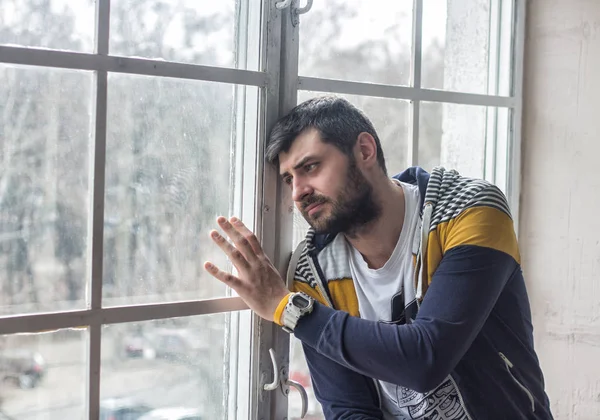 Hombre barbudo triste mirando por la ventana — Foto de Stock