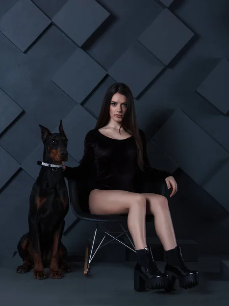 Brunette sexy en body assis avec chien doberman — Photo