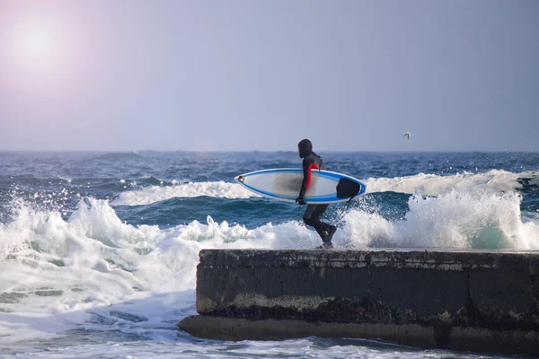 Surfer läuft im Neoprenanzug ins Wasser. — Stockfoto