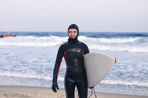 Surfer geht im Neoprenanzug aus dem Wasser — Stockfoto