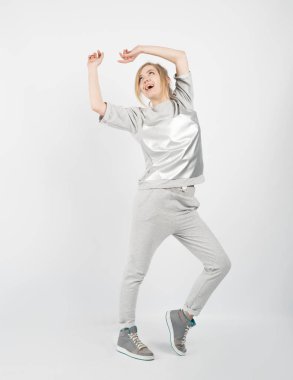 Gri elbise ve spor ayakkabı giyen genç güzel kız