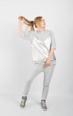 Gri elbise ve spor ayakkabı giyen genç güzel kız