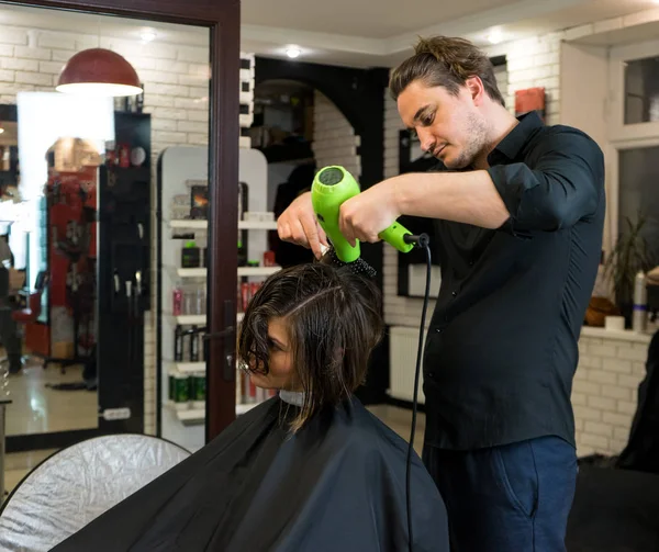 Перукар сушить волосся феном — стокове фото