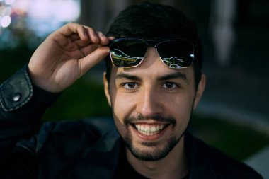 Gülümseyen adam renkli yansıması ile güneş gözlüğü