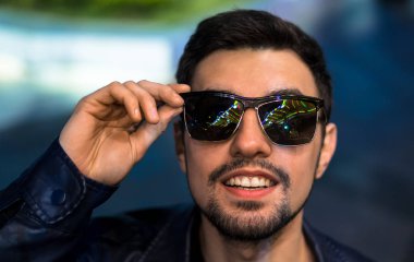 Gülümseyen adam renkli yansıması ile güneş gözlüğü