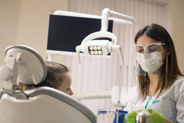 Tannlegekvinne som forbereder jentepasient – stockfoto