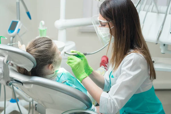 Стоматолог, лечащий зубы детей — стоковое фото