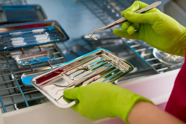 Manos del dentista sosteniendo instrumentos dentales — Foto de Stock