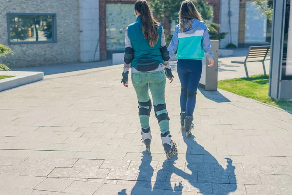 Dos niñas rodillos van uno tras otro — Foto de Stock