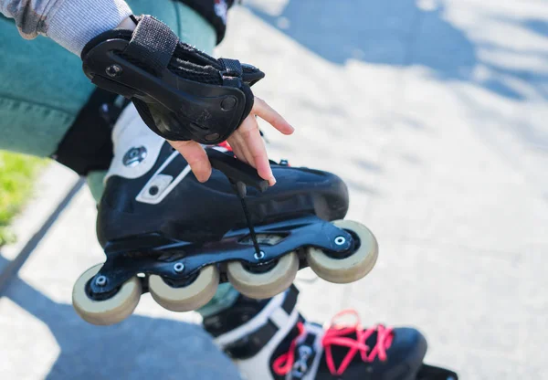 Roller girl unscrewing wheels on roller Skates with Allen key — Stock Photo, Image