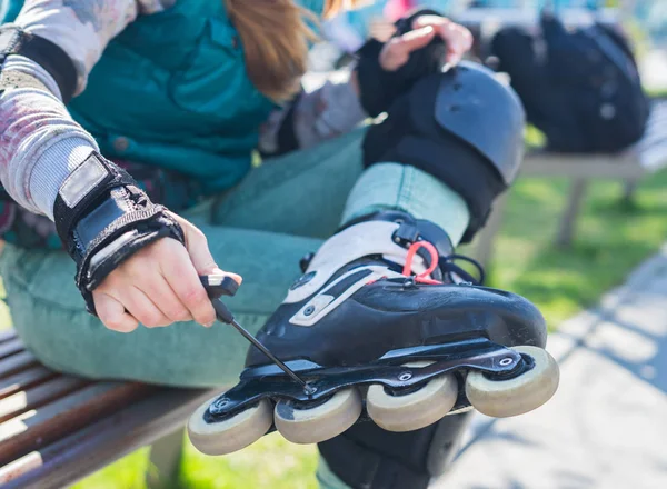 Роликові дівчина unscrewing коліс на роликових ковзанах Аллен ключами — стокове фото