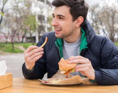 adam sokak gıda kafede hamburger ile kızarmış patates yeme