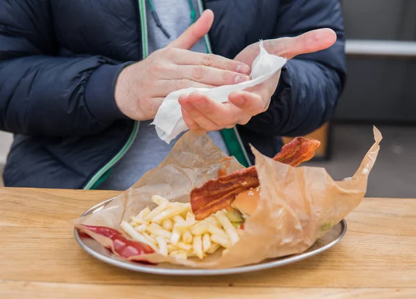 Porträt eines jungen Mannes, der seine Hände mit Feuchttüchern reinigt — Stockfoto