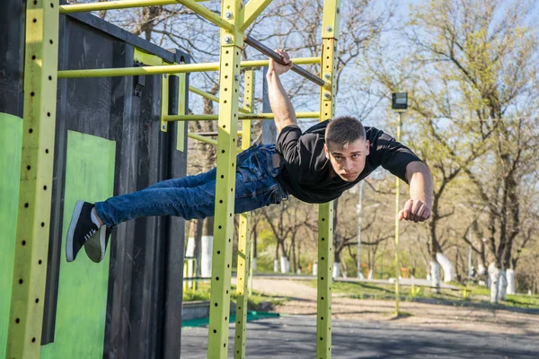Male athlete swinging on monkey bars