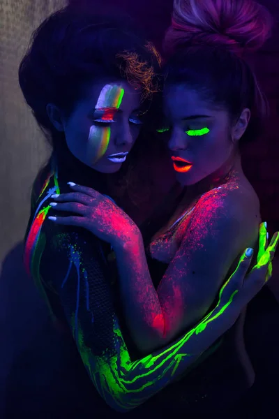 Sexy lesbische Models umarmen sich im UV-Neon-Licht — Stockfoto