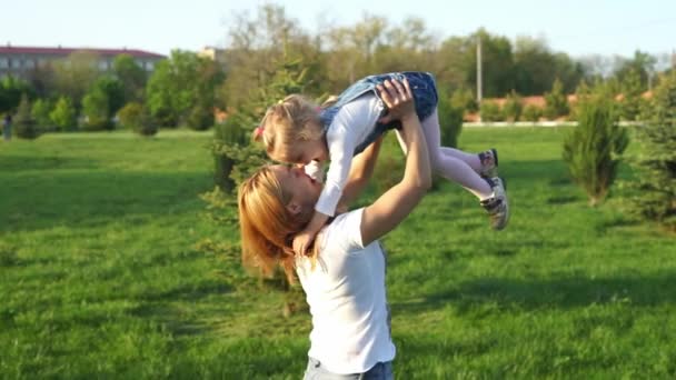 Beautiful mother lifts high her cheerful girl and laughing — Stock Video