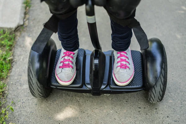 Girls legs wearing sneakers riding gyroscooter or hoverboard — Stock Photo, Image