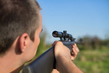 Adam amacı bir keskin nişancı tüfeği ile hedef alır. Seçici odak