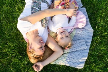 Mutlu aile anlar. Anne ve kızı parkta gülümseyen