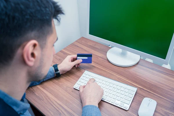 Офисный работник держит кредитную карту и делает онлайн покупки — стоковое фото