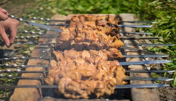Mans main retourner les kebabs ou barbecue sur un gril de briques. Concept de voyage — Photo