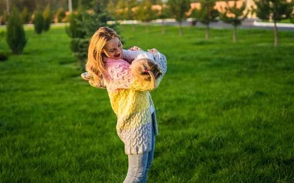 Glückliche Familie. Mutter spielt mit Tochter auf grünem Rasen mit Gras — Stockfoto