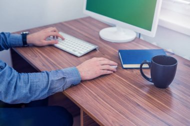Bilgisayar masa başında çalışan office erkeğin elinde