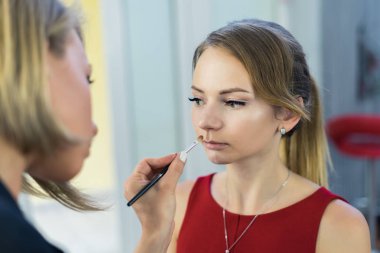 Makyöz makyaj güzel bir genç kızla yapıyor