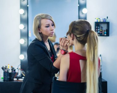 Makyöz makyaj güzel bir genç kızla yapıyor