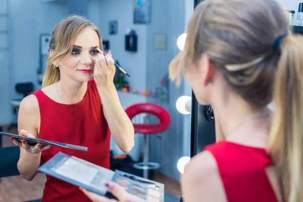 Фасіо Портрет красивої молодої дівчини, що робить макіяж біля дзеркала — стокове фото