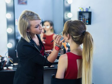 Makyöz makyaj güzel bir genç kızla yapıyor