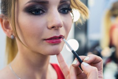 Güzel bir genç kızla dumanlı gözler makyaj yapıyor makyaj sanatçısı