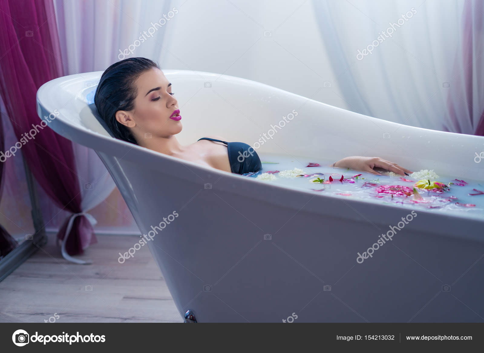 Sexy brunette woman relaxing in a hot bath with flowers Stock Photo by ©igor.kardasov.gmail 154213032 pic