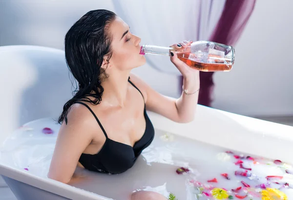 Seksowna brunetka kobieta pije szampana biorąc gorącą kąpiel — Zdjęcie stockowe