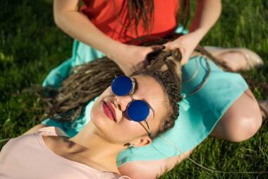 İki kız arkadaş grubu zizi cornrows dreadlockson yeşil çim.