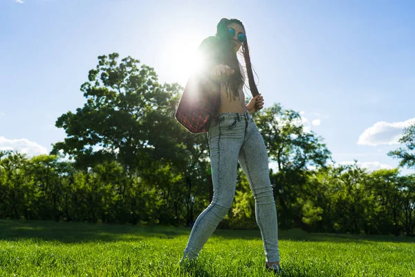 Bezstarostné dívka s zizi cornrows dredy tančí na zeleném trávníku — Stock fotografie