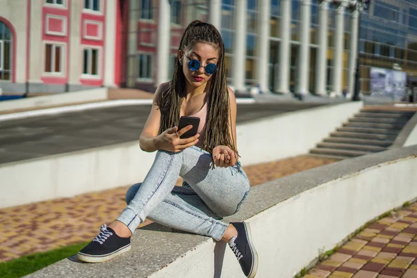 Chica con zizi cornrows teme chatear en su teléfono inteligente — Foto de Stock