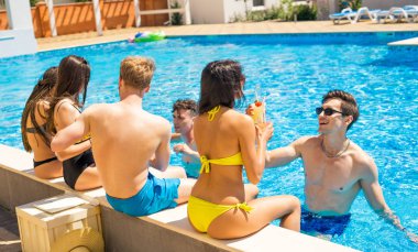 Neşeli grup içme cocktailsin havuz çiftler