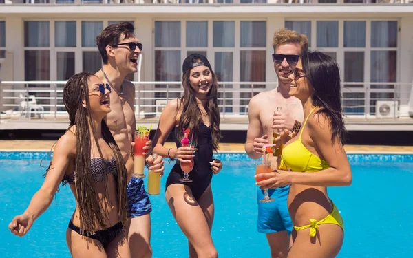 Люди пьют коктейли и пиво во время вечеринки в бассейне — стоковое фото