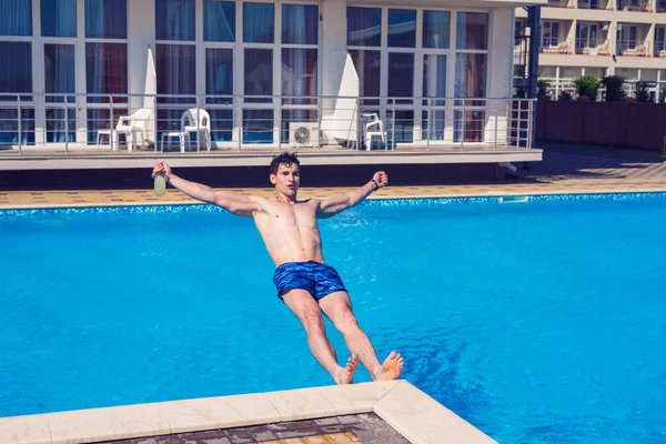 Hombre borracho cayendo al agua con cerveza en la mano —  Fotos de Stock