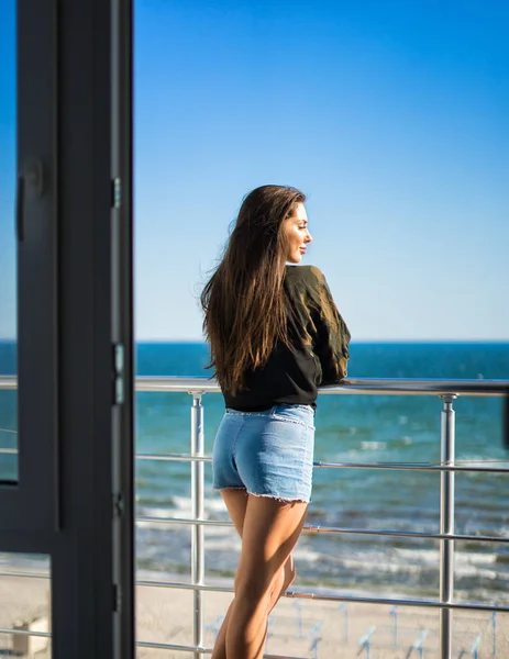 Σέξι μοντέλο γυναίκα στέκεται στο μπαλκόνι με θέα στο φόντο — Φωτογραφία Αρχείου